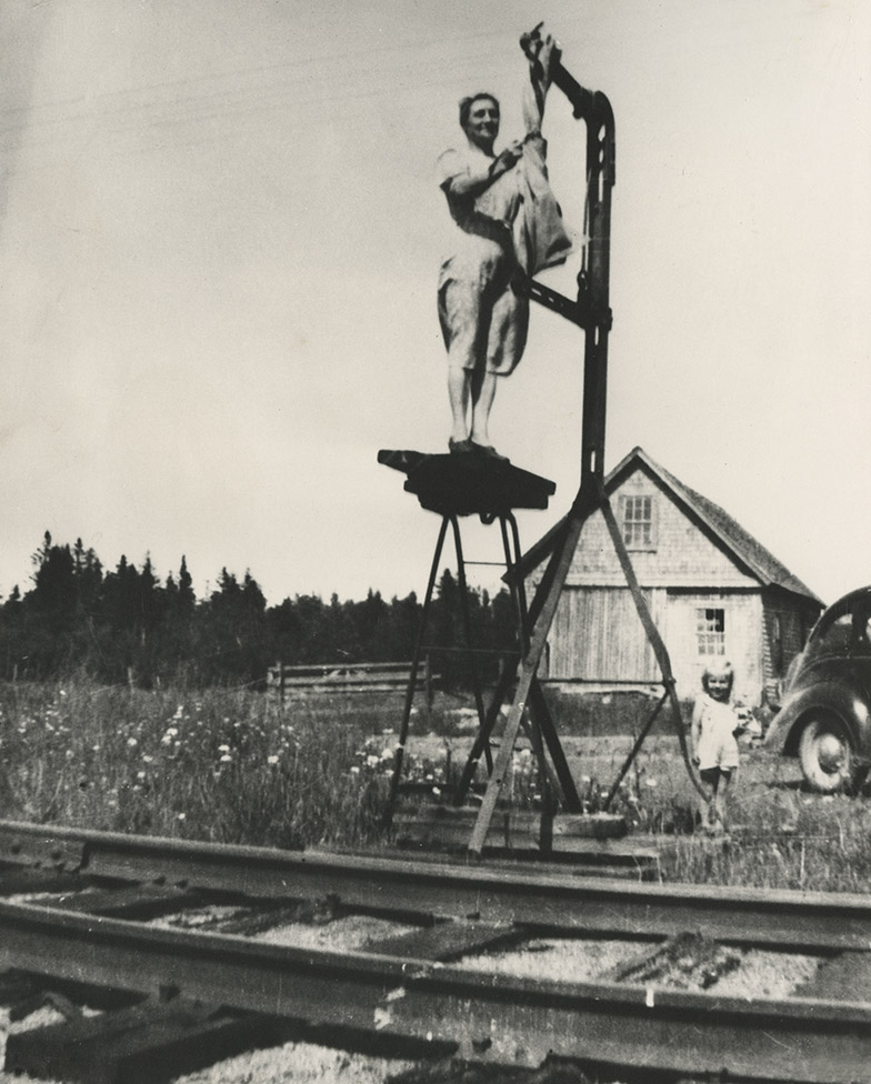 communityalbums - Minnie (LeBlanc) Geddry hangs a mailbag for pick-up by a passing train, in Maxwelton, NS