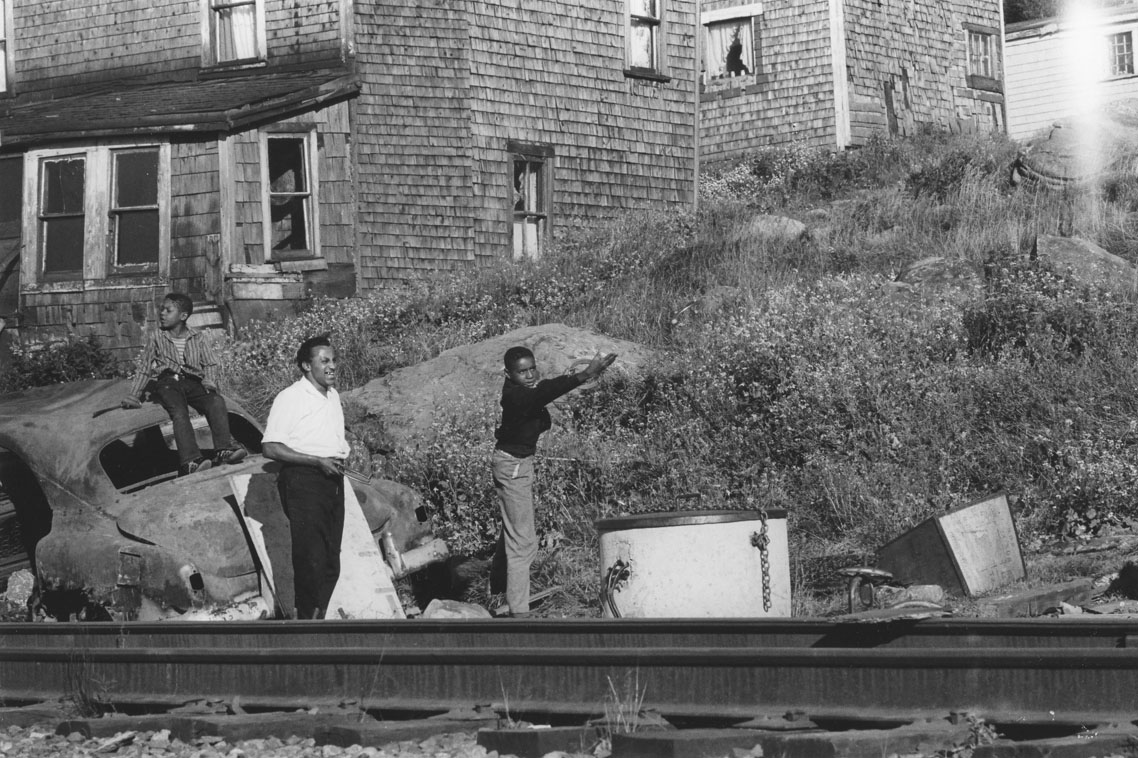 africville : Young men playing horseshoes, seen from the opposite side of the railway tracks, Africville.