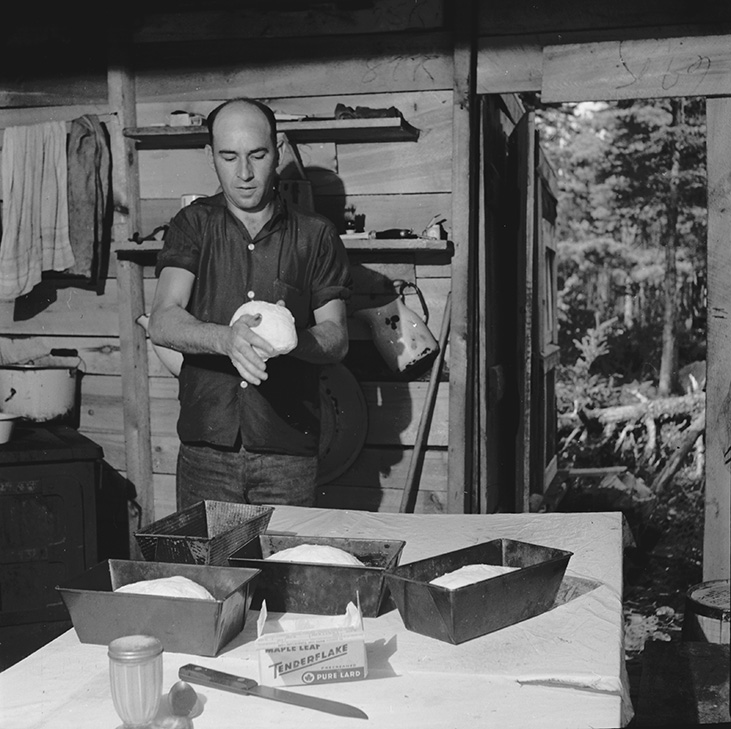 Acadian camp cook from Saulnierville Station baking bread at mid-morning