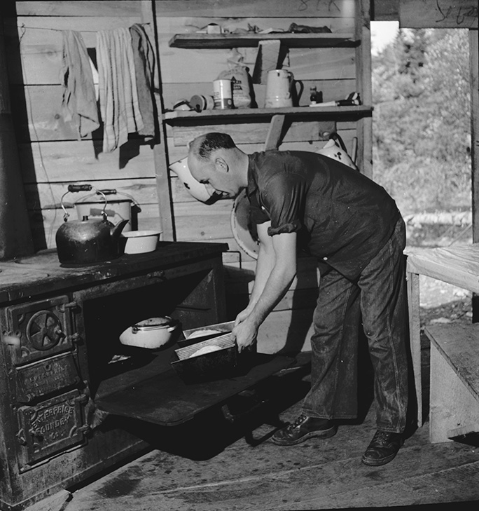 Acadian camp cook from Saulnierville Station baking bread at mid-morning