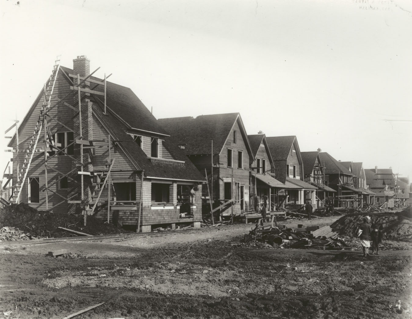 Original photograph copied through the courtesy of the Maritime Museum of the Atlantic [N.S. Education Media Services negative N-14,131].                  The temporary railway tracks served to bring materials to the Isleville Street siding for construction of hydrostone buildings.  The house at left was built using Ross & Macdonald design D.18.  The present addresses for the houses are (left to right) 5875-5877 Kaye Street.  Variations of this design were built throughout the north ends of Halifax and Dartmouth.