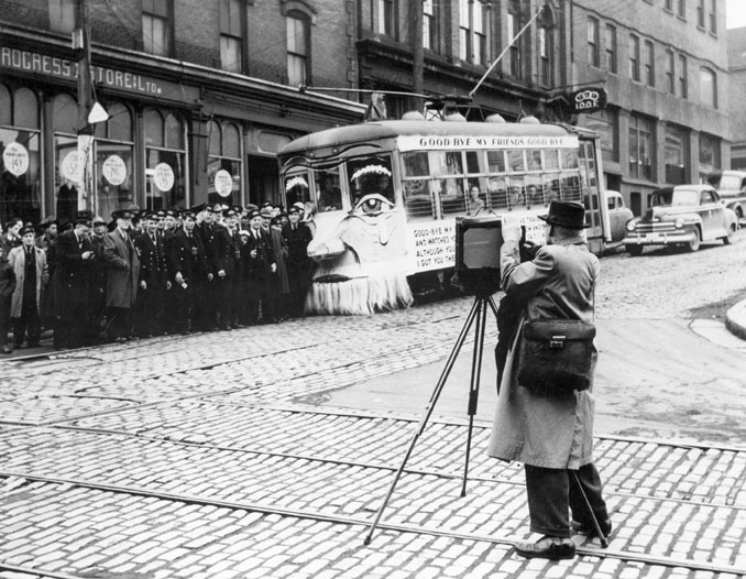Photographer, with a Camera and Tripod, Photographing a Decorated Birney Streetcar, Marking the End of Tram-Car Service in the Main Part of Halifax, 26 March 1949