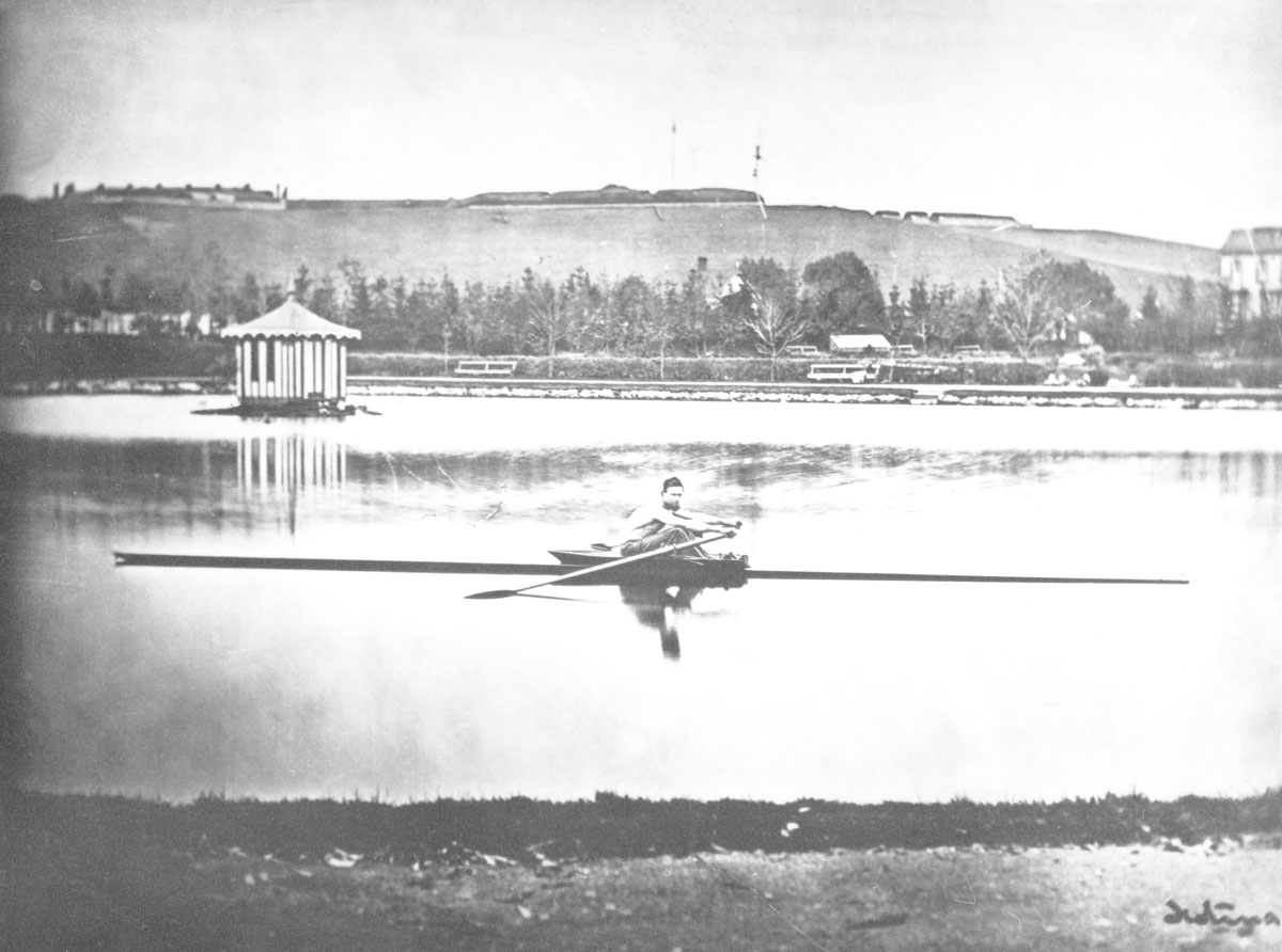 macaskill : George Brown skulling in pond, Halifax Public Gardens, Citadel Hll in background