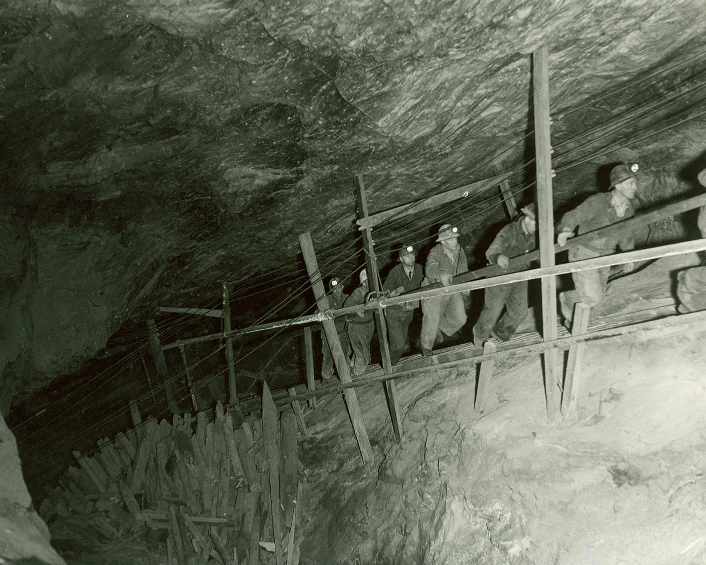 Salt miners climbing along a narrow shaft